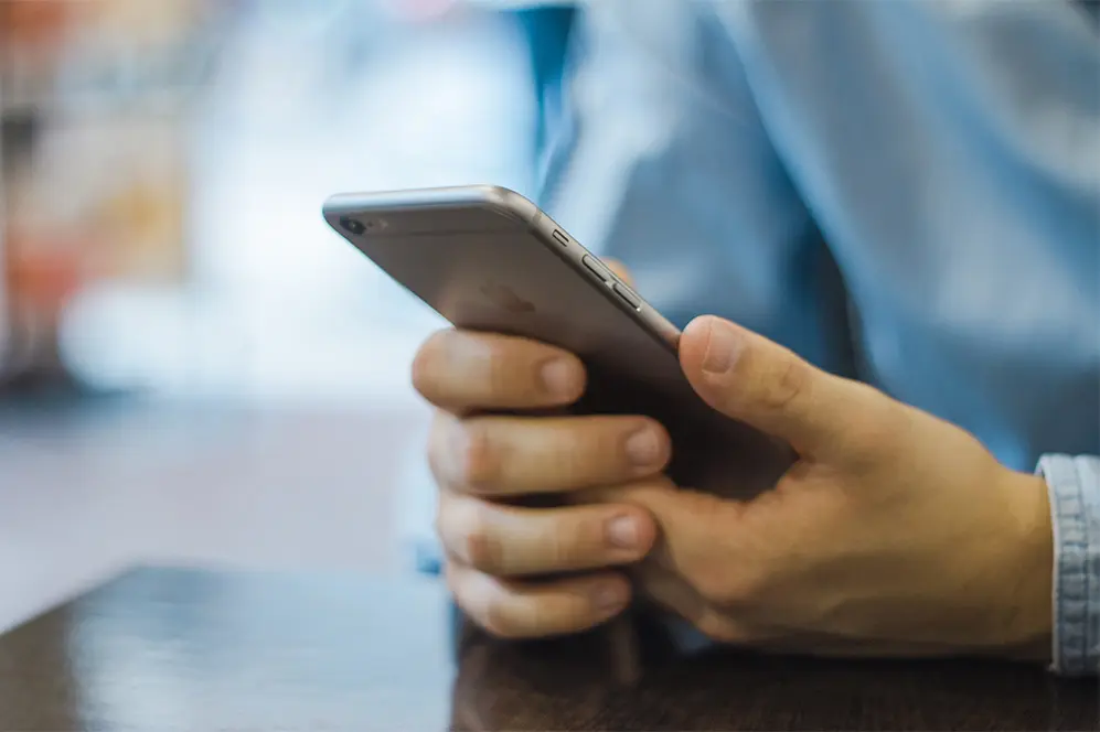 Person holding smartphone at table