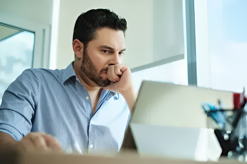 Man focused on laptop screen