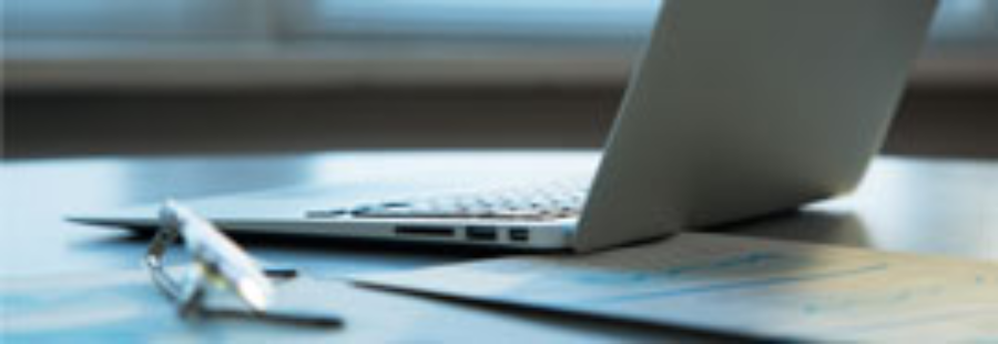 Workspace with laptop and reading glasses